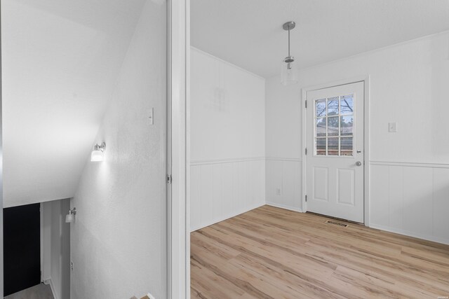 interior space featuring wainscoting, light wood-type flooring, and visible vents