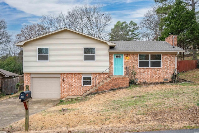 tri-level home featuring crawl space, an attached garage, concrete driveway, and brick siding