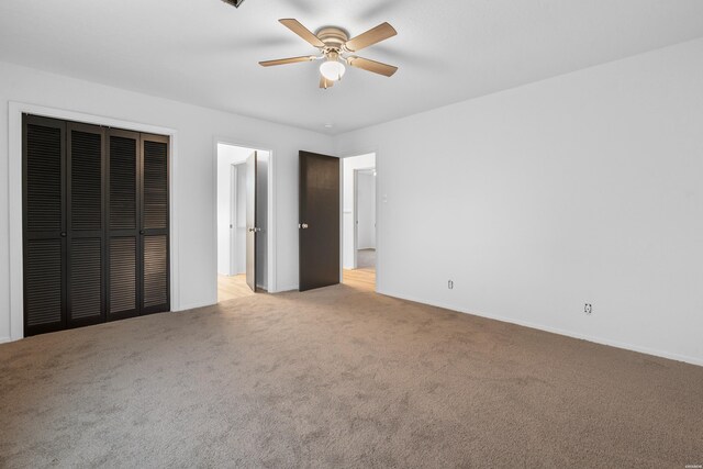 unfurnished bedroom featuring light carpet, a closet, and a ceiling fan