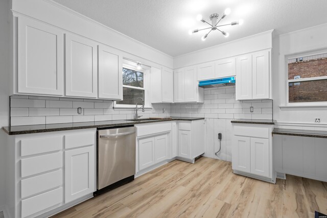 kitchen featuring tasteful backsplash, white cabinets, dishwasher, light wood-style floors, and a sink