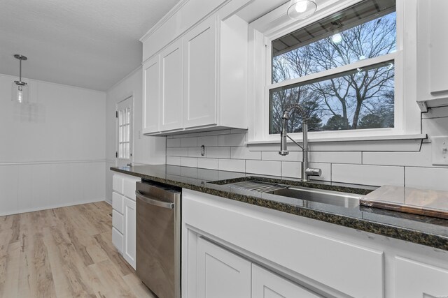 kitchen featuring dark stone counters, white cabinets, and a sink