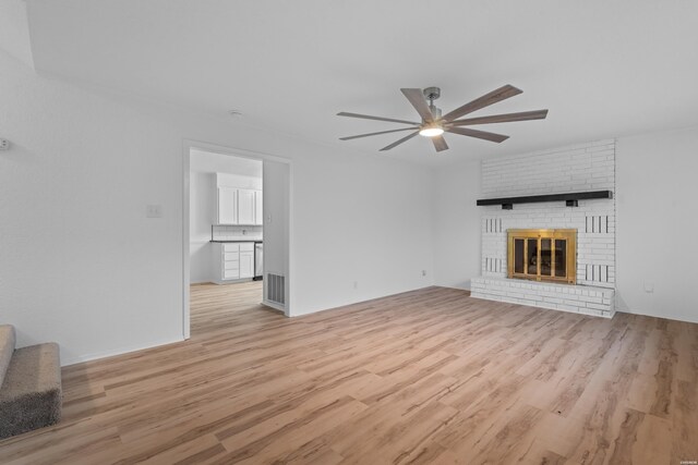 unfurnished living room featuring a brick fireplace, visible vents, ceiling fan, and light wood finished floors