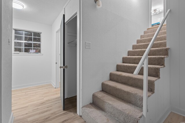 stairway featuring baseboards and wood finished floors