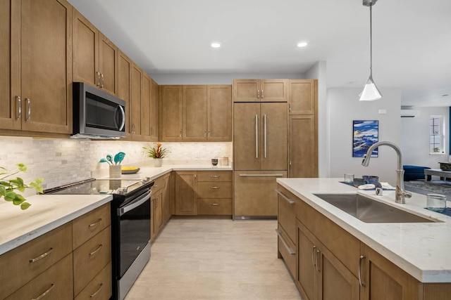 kitchen with tasteful backsplash, sink, stainless steel appliances, and hanging light fixtures