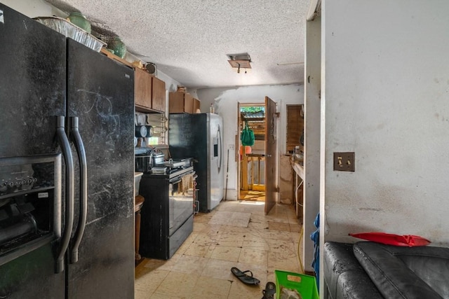 kitchen with black refrigerator with ice dispenser, electric range, light tile flooring, stainless steel fridge with ice dispenser, and a textured ceiling