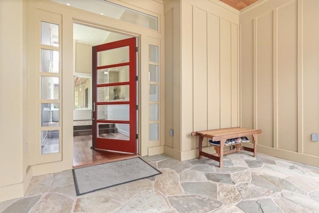 doorway to outside featuring stone flooring and a decorative wall