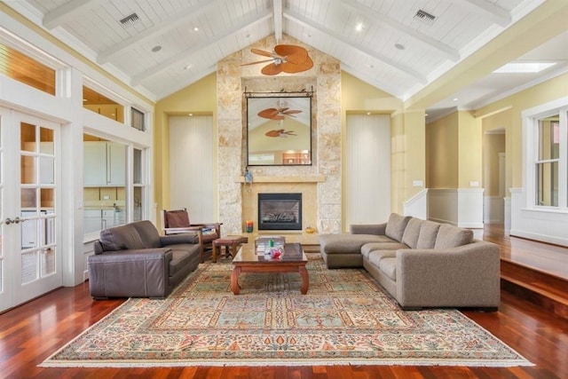 living room with visible vents, a stone fireplace, wood finished floors, high vaulted ceiling, and beamed ceiling