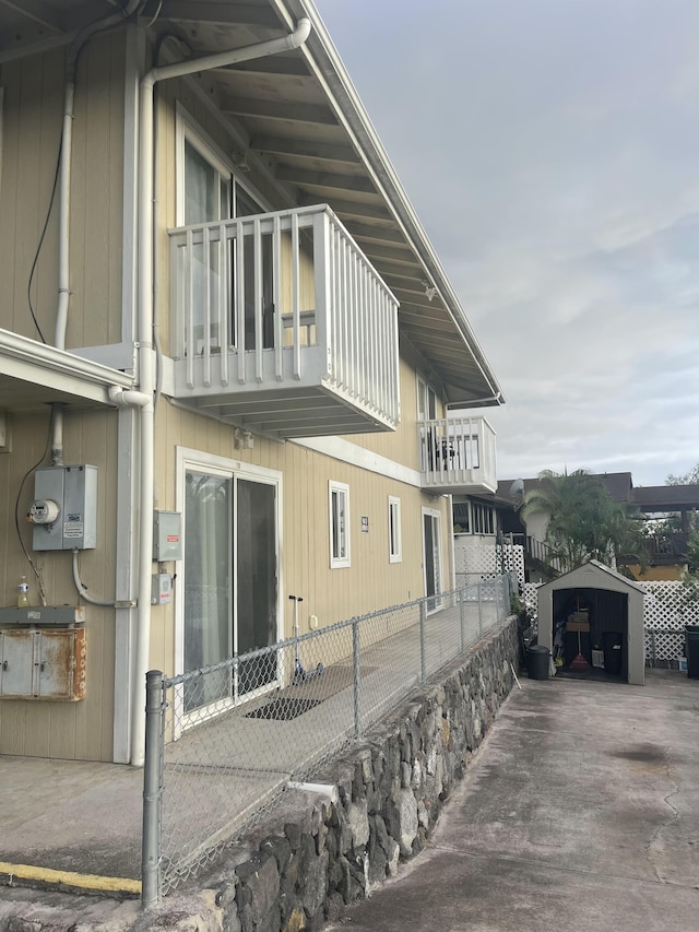 view of side of property featuring fence and a balcony