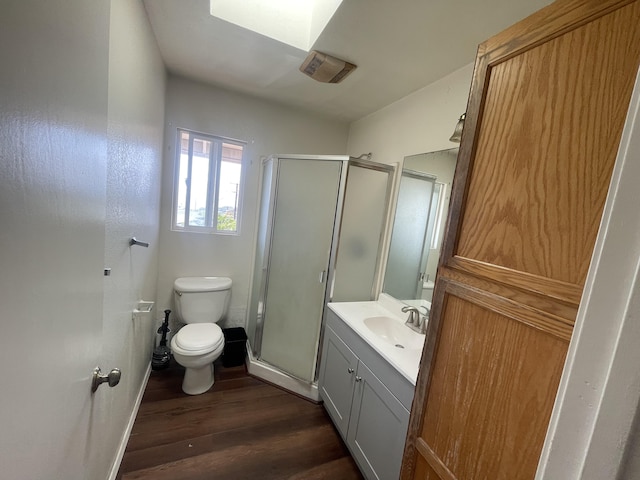 full bathroom with visible vents, toilet, a shower stall, vanity, and wood finished floors