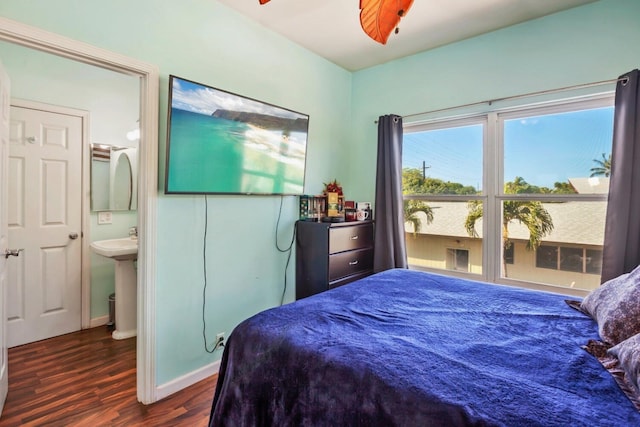 bedroom with dark hardwood / wood-style flooring, ceiling fan, ensuite bathroom, and sink