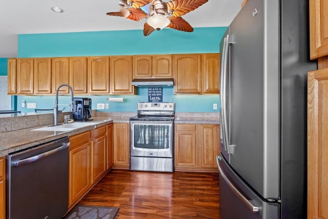 kitchen featuring dark hardwood / wood-style floors, ceiling fan, appliances with stainless steel finishes, and sink