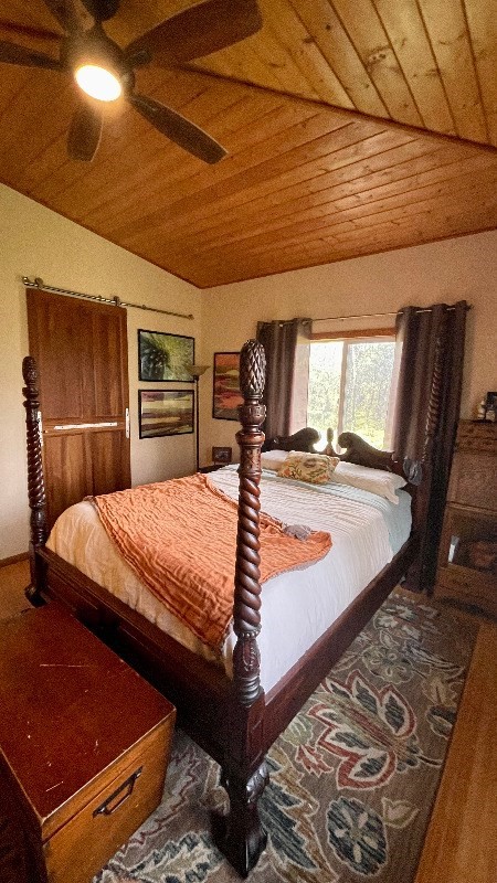 bedroom with wood ceiling, lofted ceiling, and ceiling fan