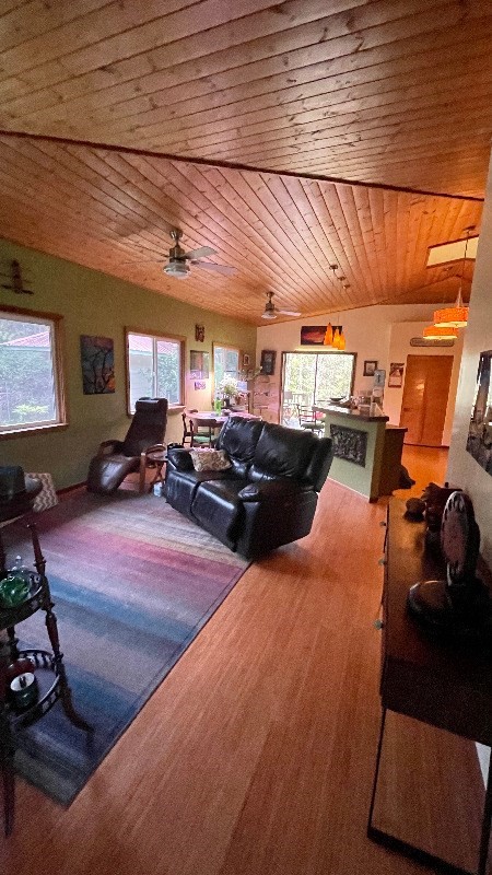 living room featuring wooden ceiling, plenty of natural light, ceiling fan, and hardwood / wood-style flooring