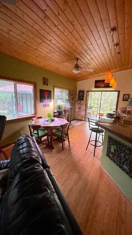 living room with wood ceiling, plenty of natural light, light hardwood / wood-style floors, and ceiling fan