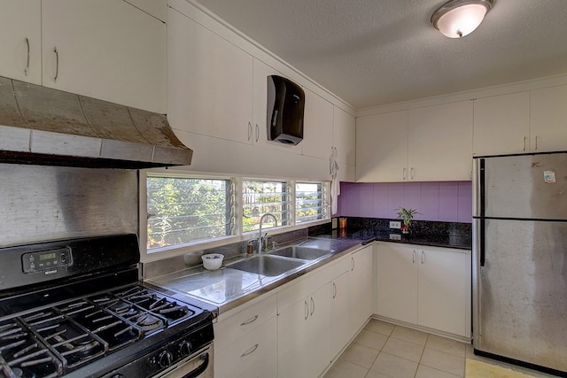 kitchen with light tile flooring, stainless steel fridge, sink, black gas range, and white cabinets