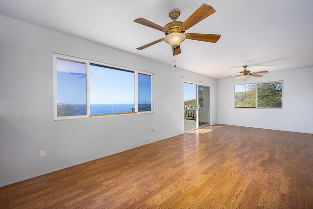 spare room with light hardwood / wood-style flooring, ceiling fan, and a water view