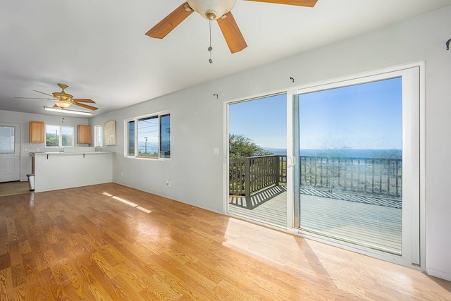 unfurnished living room with ceiling fan and light wood-type flooring