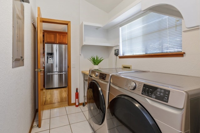 washroom with washer hookup, light tile floors, and washing machine and clothes dryer