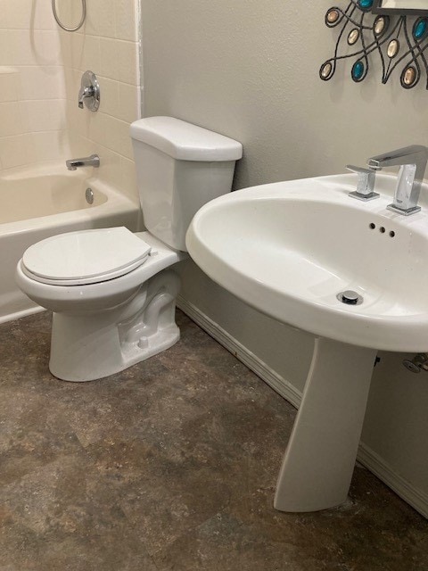 bathroom featuring tile flooring, toilet, and tiled shower / bath