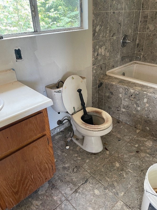 full bathroom featuring tiled shower / bath, tile flooring, toilet, and vanity