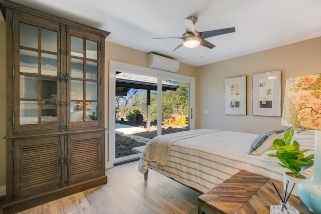 bedroom featuring ceiling fan, light hardwood / wood-style flooring, a wall unit AC, and access to outside