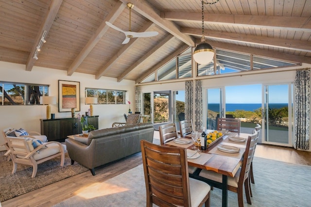 dining space featuring a water view, wooden ceiling, ceiling fan, and beamed ceiling