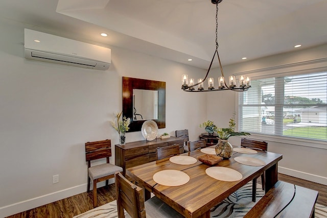 dining area featuring dark wood-type flooring, a notable chandelier, and a wall unit AC