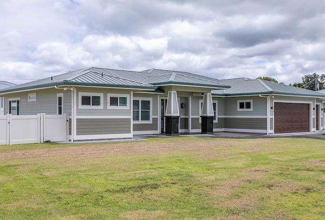 rear view of house with a lawn and a garage