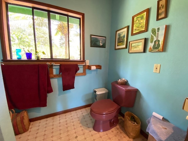 bathroom with toilet, a healthy amount of sunlight, and tile flooring