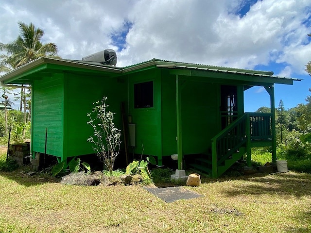 view of side of home featuring central AC unit and a yard