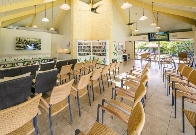 interior space with brick wall, high vaulted ceiling, ceiling fan, and beamed ceiling