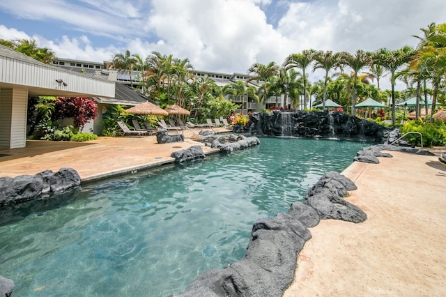 view of swimming pool featuring pool water feature and a patio