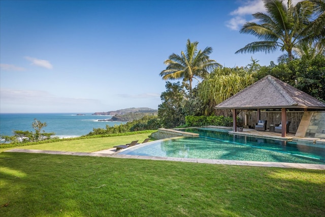 view of swimming pool with a lawn, a gazebo, and a water view