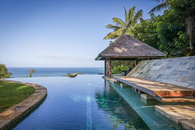 view of swimming pool with a gazebo and a water view