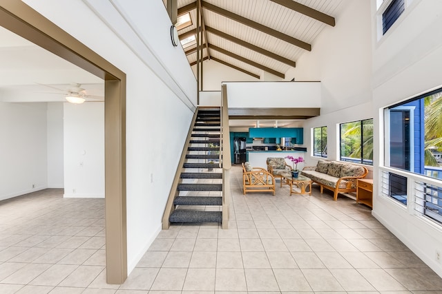 staircase with high vaulted ceiling, beam ceiling, light tile flooring, and ceiling fan