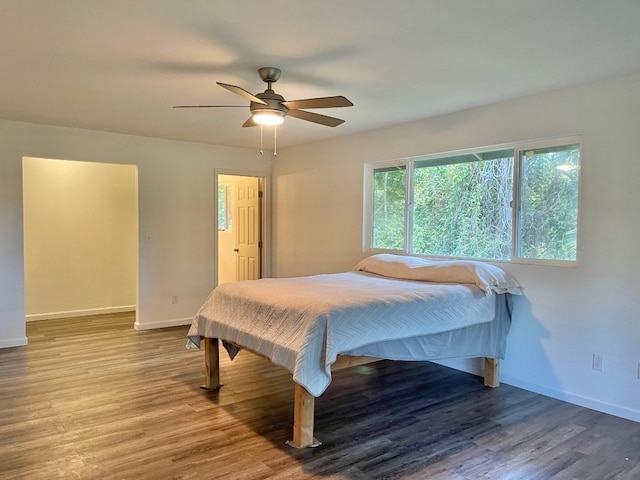 bedroom with dark hardwood / wood-style flooring and ceiling fan