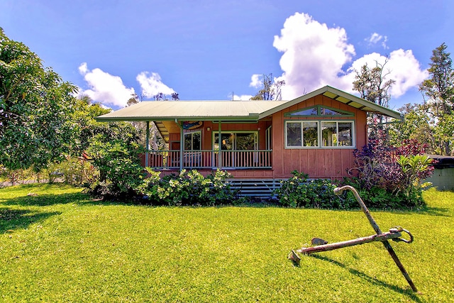 back of property featuring a lawn and a deck