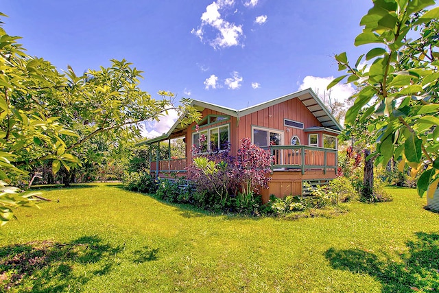 view of home's exterior with a wooden deck and a yard