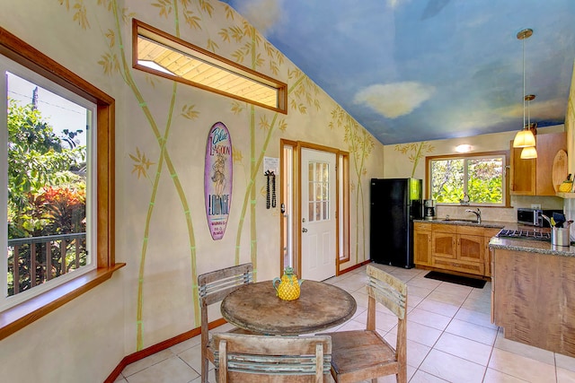 dining space with vaulted ceiling, light tile floors, and sink