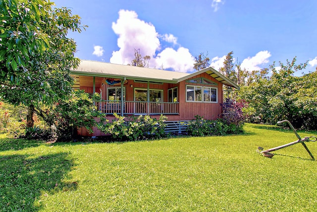 view of front facade featuring a wooden deck and a front yard