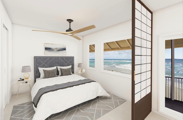 tiled bedroom with a water view, a view of the beach, and ceiling fan