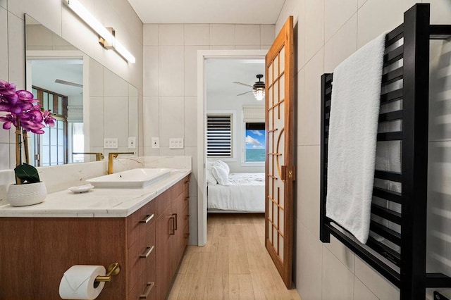 bathroom featuring ceiling fan, tile walls, and a healthy amount of sunlight