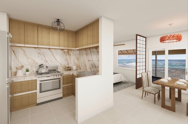 kitchen featuring a water view, stainless steel fridge, light tile floors, and gas range gas stove