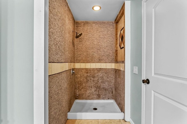 bathroom featuring a tile shower and tile patterned flooring