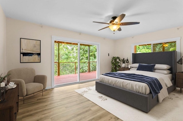 bedroom with access to exterior, hardwood / wood-style flooring, multiple windows, and ceiling fan