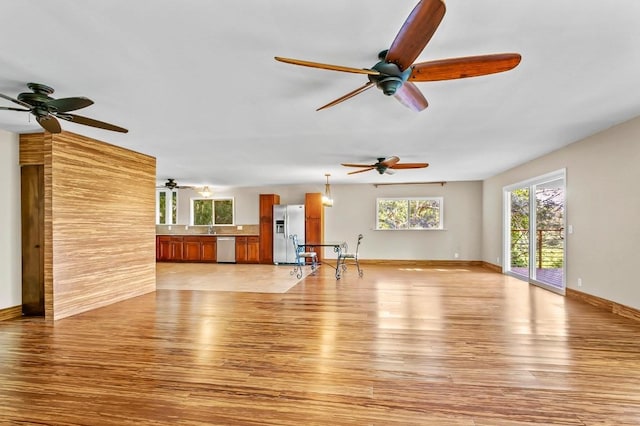 unfurnished living room with sink and light wood-type flooring