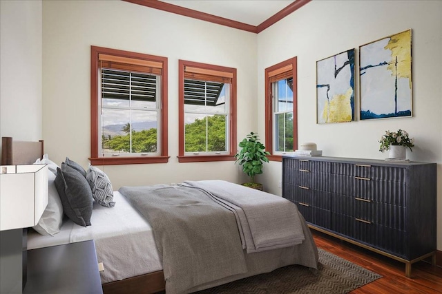 bedroom with crown molding and dark hardwood / wood-style flooring