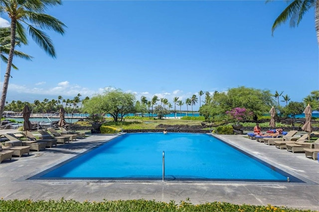 view of swimming pool with a water view and a patio area