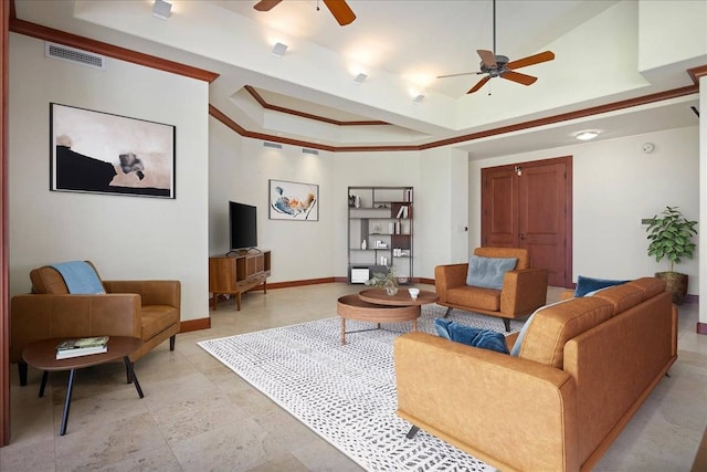 living room featuring crown molding, ceiling fan, and a raised ceiling