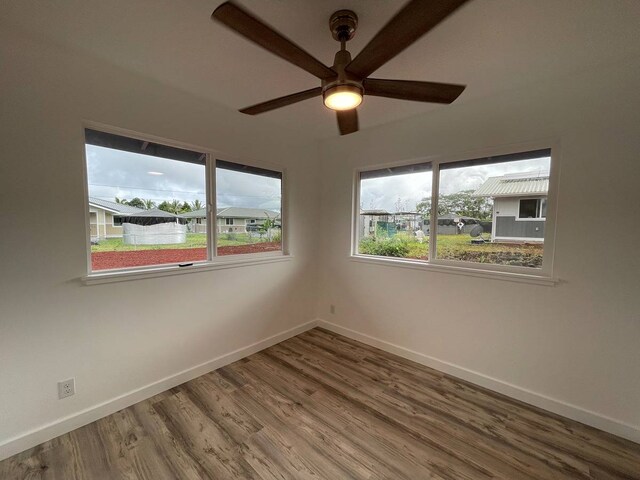 empty room with ceiling fan and dark hardwood / wood-style flooring